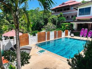 Haad Son赏金度假酒店的一座棕榈树游泳池和一座建筑