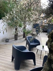 旺德夫尔莱南锡Maison d'hotes L'atelier du Charmois的一个带椅子和桌子的庭院和一棵树