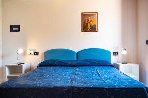 皮肖塔Lido Paradiso Resort的卧室内的一张蓝色床,配有两盏灯