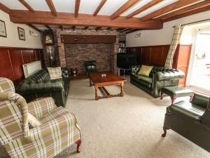 莫珀斯The Granary的客厅配有皮革家具和壁炉