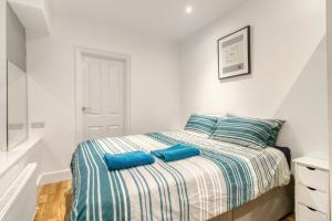 伦敦Holland Park Apartment的一间卧室配有一张带蓝色枕头的床。