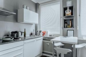 明斯特Stylisches Münster City-Apartment 83 m²的厨房配有白色橱柜和桌椅