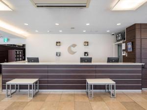 东京东京清澄白河康福特茵酒店的一间设有柜台和两张桌子的等候室