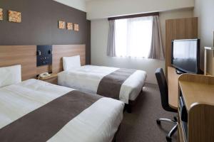 堺市舒适酒井酒店 的酒店客房设有两张床和一台平面电视。