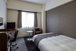 堺市舒适酒井酒店 的配有一张床、一张书桌和一扇窗户的酒店客房
