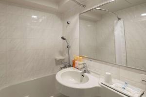 堺市舒适酒井酒店 的一间带水槽、浴缸和镜子的浴室
