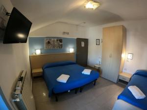 Staranzano阿尔贝格拉卡拉维拉酒店的一间医院间,配有蓝色的床和电视