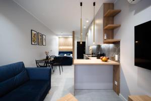 别尔斯克-比亚拉Apartament pod Szyndzielnią的厨房以及带蓝色沙发的起居室。