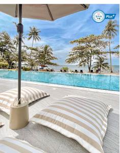 库德岛Shantaa Resort, Kohkood的游泳池旁配有两个枕头和一把遮阳伞