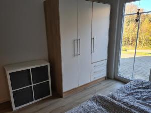 施马伦贝格Ferienwohnung Hennemann的卧室配有白色橱柜、床和窗户。