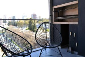 内乌肯Loi Flats Edificio Tucuman的靠窗的阳台的椅子