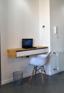 内乌肯Loi Flats Edificio Tucuman的一张桌子,墙上挂着一台笔记本电脑,配有椅子