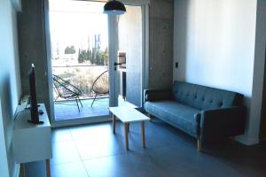 内乌肯Loi Flats Edificio Tucuman的带沙发、桌子和窗户的客厅