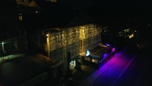 格兰贝伊佩雷贝勒Spa酒店的一座晚上在前面有紫色灯的建筑