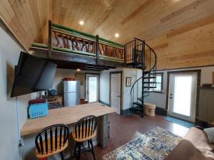 亨德森维尔Rustic Farm Stay in a Hendersonville Studio!的一间客厅,内设一张双层床和一个小房子内的楼梯