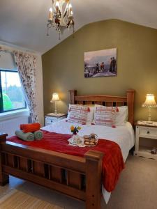 阿达拉Hillhead House的一间卧室配有一张带红色毯子的大床