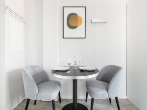 美因河畔法兰克福numa I Blau Apartments的白色的用餐室配有桌子和两把椅子