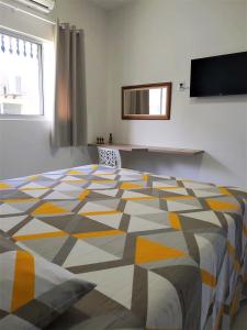 帕里普埃拉Casa Eco Fiore 58的一间卧室配有一张黄色和灰色图案的大床