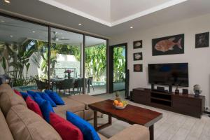 拉威海滩特罗皮可卢克巴瓦尔别墅的带沙发和电视的客厅