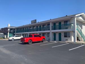 胡尔伯克GreenTree Inn of Holbrook, AZ的停在大楼前停车场的一辆红色卡车