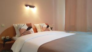 迪德朗日Hôtel La Charbonnade的一间卧室配有一张带白色床单的大床