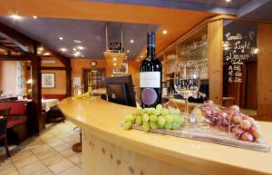 布亨REINHARDTs HOTEL的酒吧,提供一瓶葡萄酒和一束葡萄