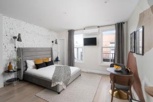 蒙特利尔François-Denis Apartments的卧室配有床和白色砖墙