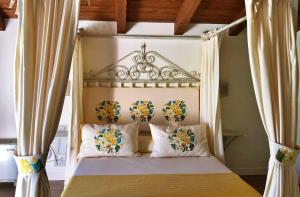 圣塔·马里亚·迪·帕尔玛Inghirios Wellness Country Resort的一间卧室配有带鲜花的天蓬床