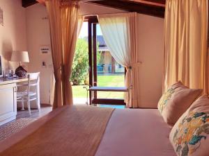 圣塔·马里亚·迪·帕尔玛Inghirios Wellness Country Resort的一间卧室配有一张床、一张书桌和一个窗户。