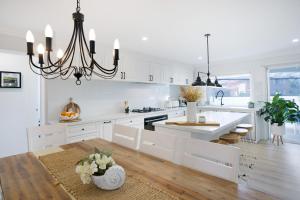 Lake IllawarraEntire Residential Home - Lake Illawarra Hampton的厨房配有白色橱柜和吊灯。