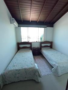 卡波布里奥Cobertura em cabo frio的客房设有两张床和窗户。
