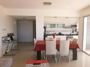 玛德琳港Costa Mar的厨房以及带红色桌子和白色椅子的用餐室。