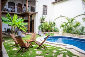 格拉纳达Hotel Patio del Malinche的一个带椅子的庭院和一个游泳池