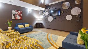 奥斯汀奥斯汀机场贝斯特韦斯特普拉斯套房酒店的带沙发的客厅和带板的墙壁