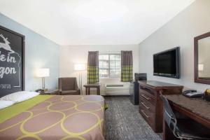 尤金Gateway Inn & Suites Eugene-Springfield的配有一张床和一台平面电视的酒店客房