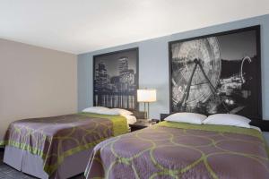 尤金Gateway Inn & Suites Eugene-Springfield的酒店客房设有两张床,墙上挂着一张照片。