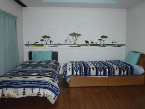 常滑市Mike's B&B Tokoname的一间卧室设有两张床,墙上有树木