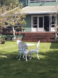 罗托鲁瓦Amberly House Rotorua的房子前面的两把椅子和一张桌子