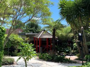 帕拉帕拉乌穆Twin Oaks Quiet Cottage的棕榈树花园中的红色结构