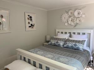 帕拉帕拉乌穆Twin Oaks Quiet Cottage的一间卧室配有一张带蓝色和白色枕头的床