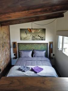 波特雷里约斯CASA FARO ARTE的一间卧室配有一张带紫色毛巾的床