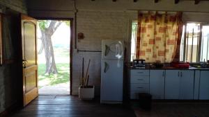 埃塞萨Los Arboles, casa completa a 5 minutos del Aeropuerto Ezeiza的厨房配有白色冰箱和窗户。