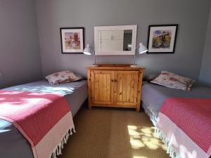 KlaarstroomAngelierbosch Guest House的一间卧室配有两张床和一个带镜子的梳妆台