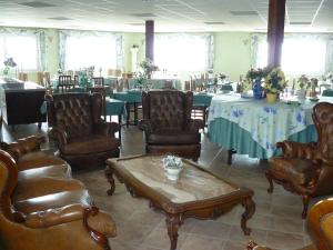 霍斯皮塔勒·德尔英福Hotel Villaclara的配有皮椅和桌子的房间以及一张桌子。