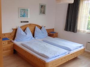 魏勒格克恩公寓的一间卧室配有一张带蓝色枕头的木床。