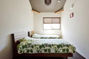 京都雅度假屋的一间小卧室,配有两张床和窗户