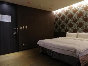 台北山乐温泉酒店的一间卧室配有一张床,一扇门设有墙壁