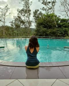玛纳多迪Serene Crest Resort的坐在游泳池前的女人