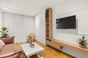 雅典Little Athens的客厅配有沙发和墙上的电视