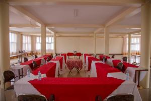 SorotiThe Sparrow Hotels的一间设有红色和白色桌椅的房间